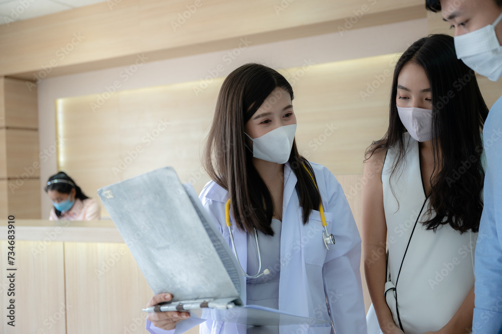 Fototapeta premium Asian female doctor and patient discussing or having a conversation about the result of symptom or diagnosis. Doctor explained or advice patient's condition, next appointment check up and prescription