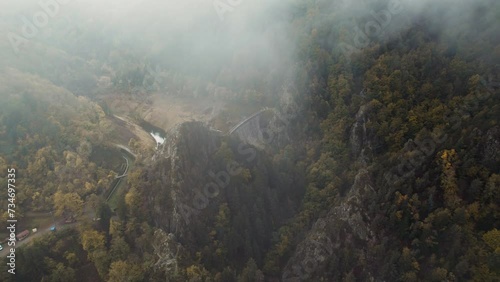 drone shot revealing gouffre d'enfer dam near saint etienne on a moody day with fog and low clouds, fance photo