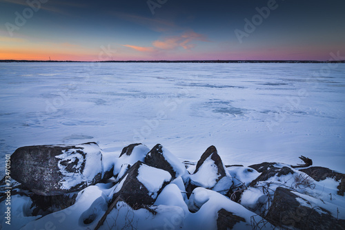 Winter view of the Quebec with a sunset on the frozen St. Lawrence river. photo