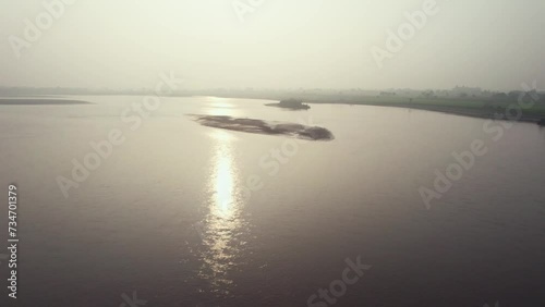 Dreamy aerial view of sunlight reflection in the muddy Chenab river in Pakistan. photo