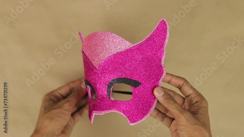 Hands making Owlette mask with pink diamond foam for carnival. PJ Mask character photo