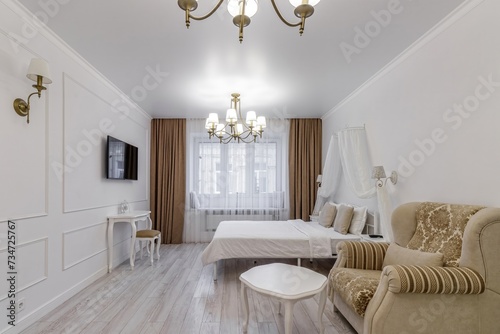 Interior in light colors with a bio fireplace, illuminated by burning sconces on the wall
