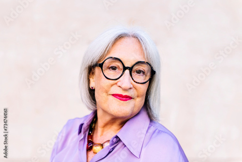 portrait of nice senior woman in glasses smiling looking at camera, concept of happiness of elderly people and active lifestyle, copy space for text