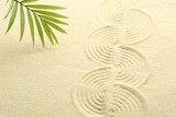 Zen rock garden. Wave pattern and green leaf on beige sand