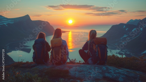 young women watching sunset, Senja island, Norway photo