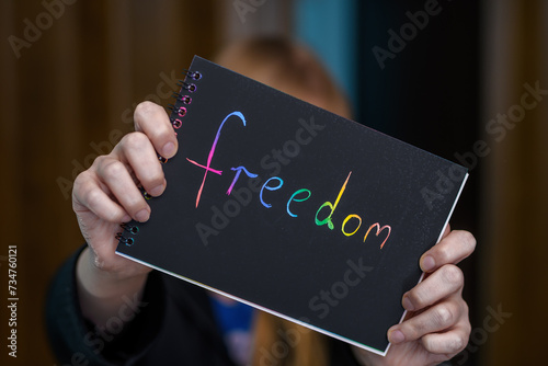 Napis na kartce wolność trzymany w dłoniach, freedom photo