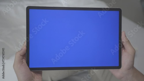 Asian Man Holding Tablet with Blue Screen in Straight Shot