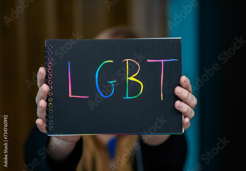 Kobieta trzyma kartkę z kolorowym napisem LGBT © Paweł Kacperek