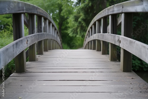 focus on wooden footbridge with soft greenery in the distance