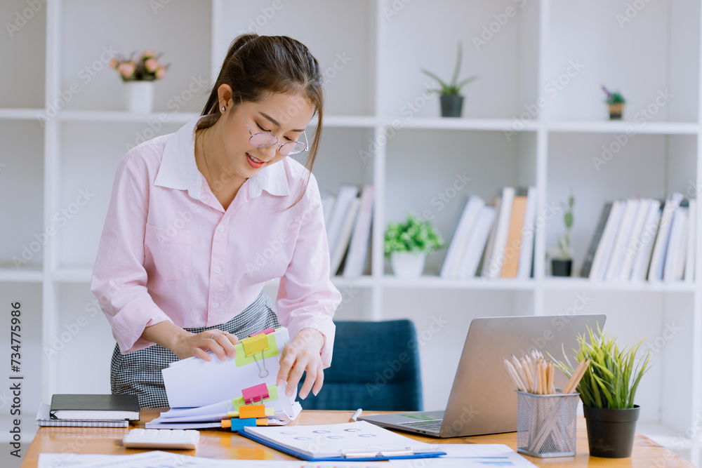 Happy asian young businesswoman holding stack of documents in office working space, Female employee with stack of business overload paper concept. Happy asian young businesswoman holding stack of documents in office working space, Female employee with stack of business overload paper concept.