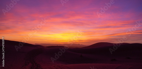 Vibrant sunrise over a scenic desert with dunes