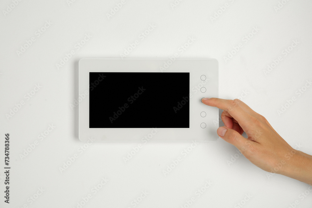 Fototapeta premium Woman using modern video intercom indoors, closeup