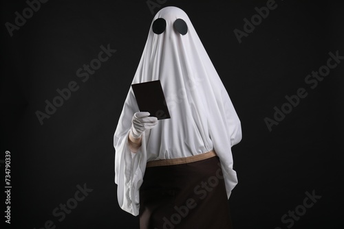 Creepy ghost. Waiter in white sheet and apron with receipt on black background