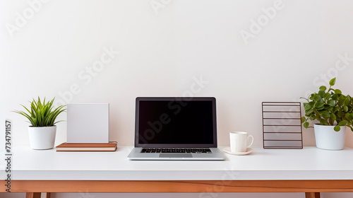 Workplace with computer and office supplies on table, minimalist interior. Sunlight from the window, shadows.