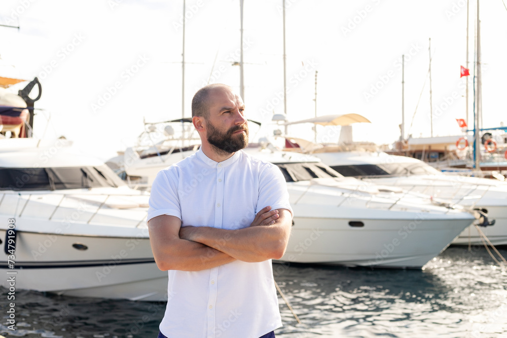 Photo of handsome man with luxury yacht in port