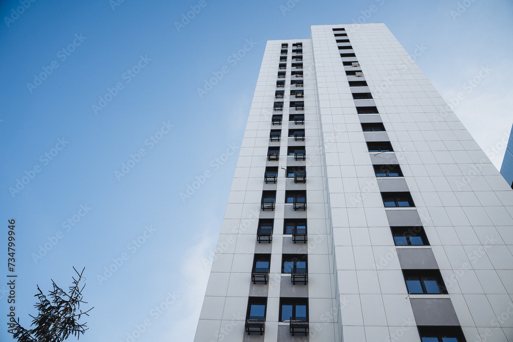 An imposing high-rise apartment building with a modern exterior made of glass and concrete. An imposing high-rise apartment building with a modern exterior made of glass and concrete.