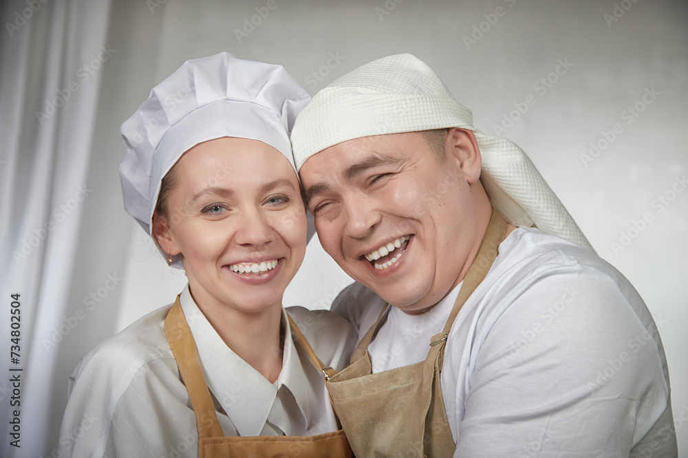Cute oriental family with wife and husband cooking in the kitchen on Ramadan, Kurban-Bairam, Eid al-Adha. Funny couple of cooks at joke photo shoot. Pancakes, pastries, Maslenitsa, Easter Cute oriental family with wife and husband cooking in the kitchen on Ramadan, Kurban-Bairam, Eid al-Adha. Funny couple of cooks at joke photo shoot. Pancakes, pastries, Maslenitsa, Easter