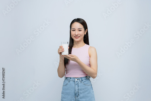 Healthy Asian woman drinking a glass of milk isolated on white background.
