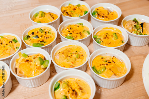 Cheddar Polenta and Asparagus Ramekin Dishes. Oven prepared ramekins filled with creamy polenta, tender asparagus, and rich cheddar sauce, served on a wooden table.