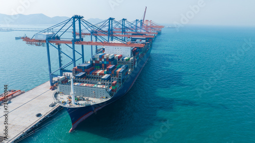 crane loading cargo container from truck to container ship in the international terminal logistic sea port concept freight shipping by ship