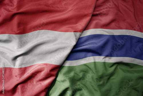 big waving national colorful flag of gambia and national flag of austria .
