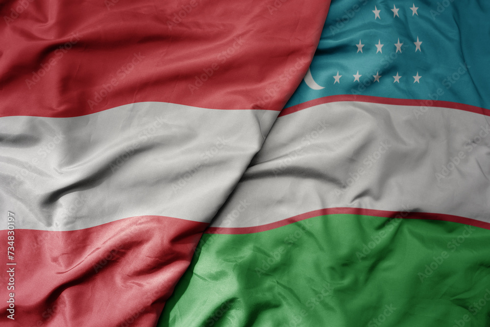 big waving national colorful flag of uzbekistan and national flag of austria .