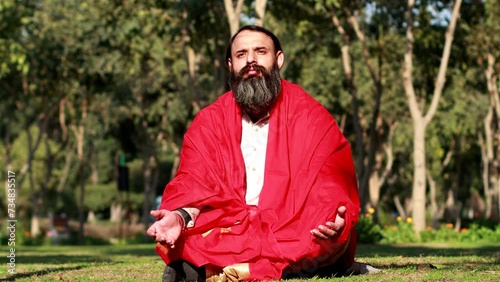 Mid adult beard yogi practicing Kapal bhati yoga outdoor in the park. photo