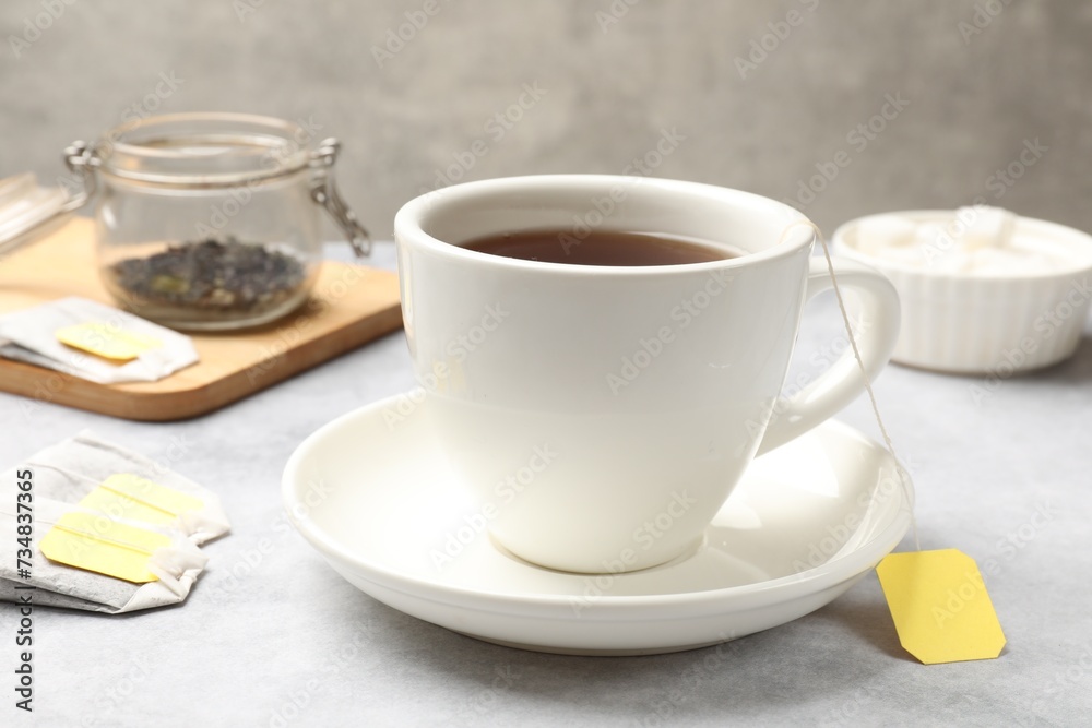 Tea brewing. Cup with hot drink and tea bags on light table, closeup Tea brewing. Cup with hot drink and tea bags on light table, closeup