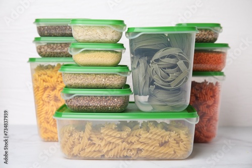 Plastic containers filled with food products on white table