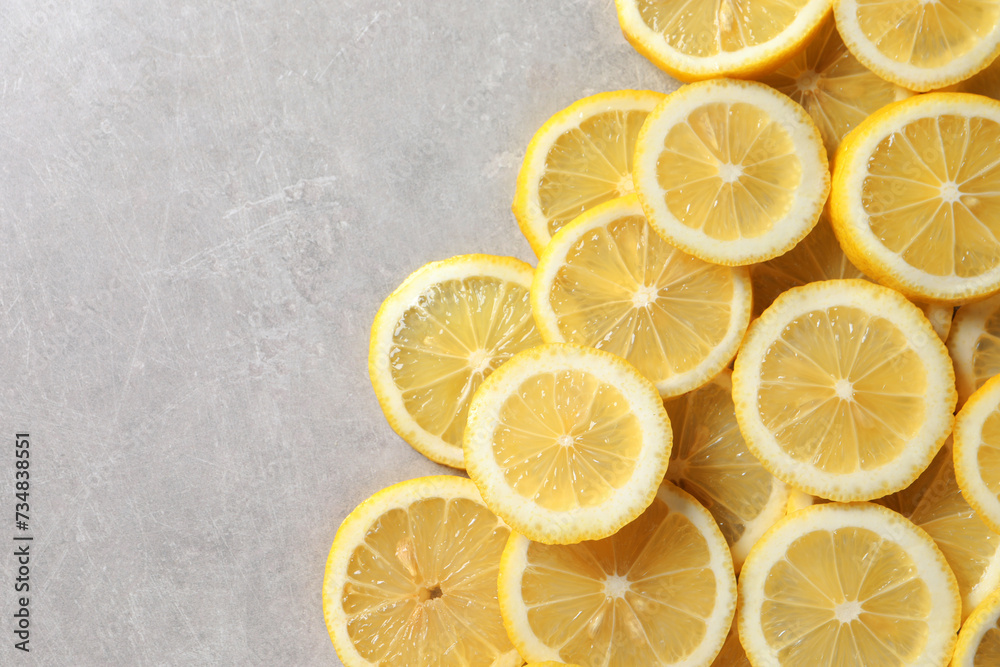 Slices of fresh lemons on grey table, top view. Space for text