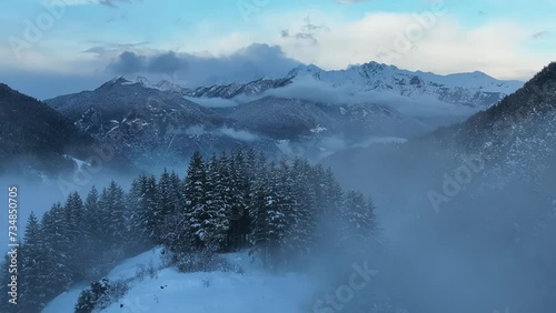 Aerial drone view of foggy Town in dolomites in Italty. Italian mountain town Berguzzo in alps. Adamello Brenta park in dolomites Trentino. Cloudy winter day in small town in the Italian mountains.  photo