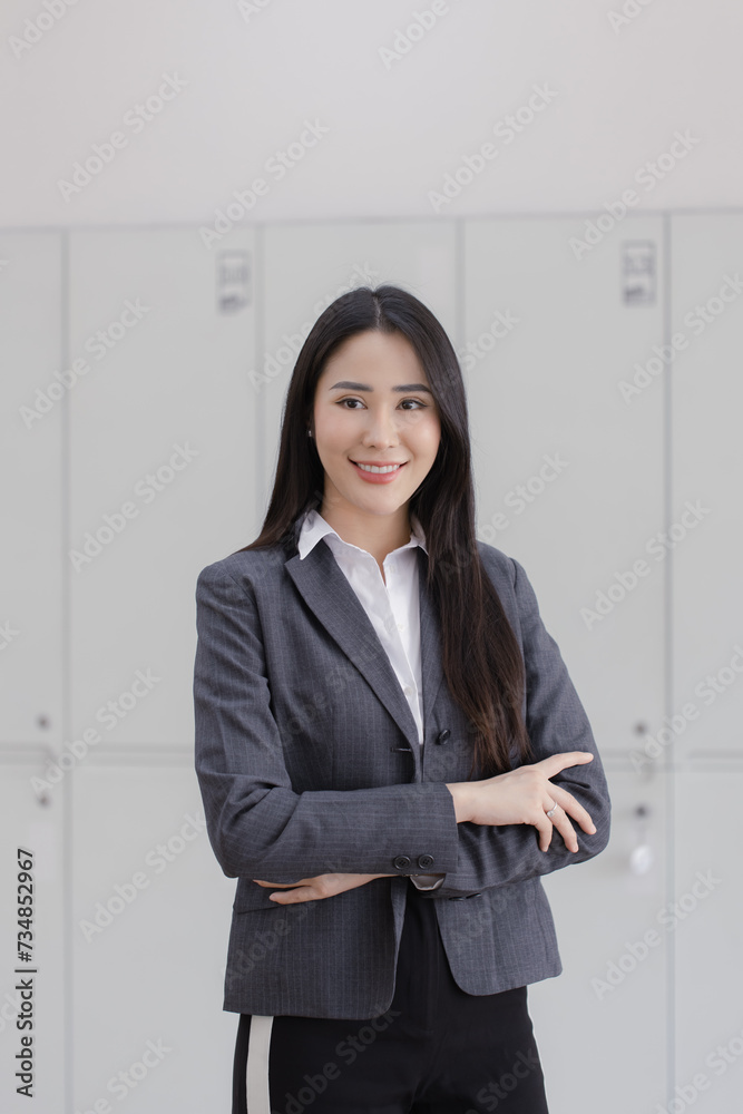Happy asian young businesswoman arms crossed standing in office working space. Happy asian young businesswoman arms crossed standing in office working space.