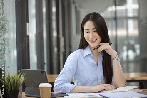 Happy asian accounting businesswoman working in office working space, Asian female employee using laptop at workplace.