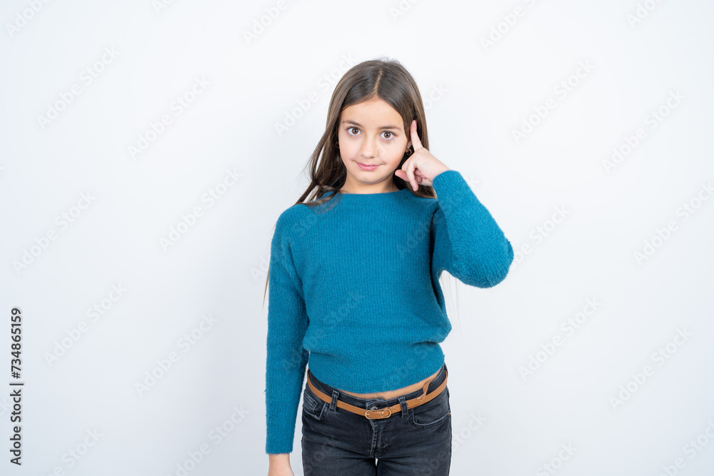 Young beautiful teen girl wearing blue T-shirt tries to memorize something, keeps fore finger on temple, reminds information for exam, Young beautiful teen girl wearing blue T-shirt tries to memorize something, keeps fore finger on temple, reminds information for exam,