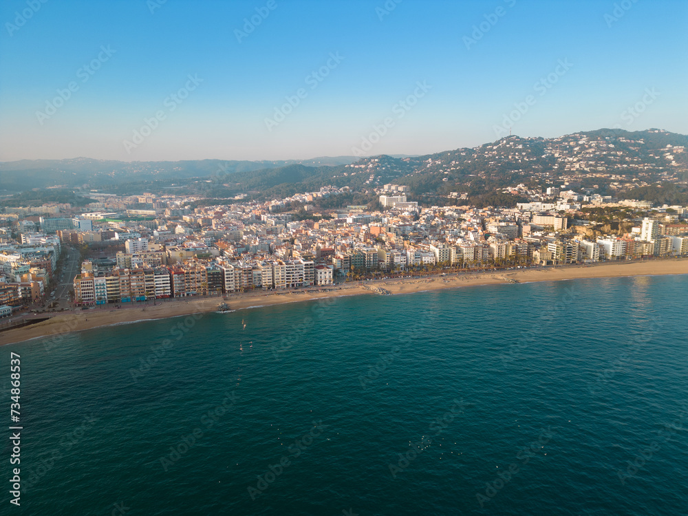 Aerial view of Lloret del Mar City. Mediterranean coastal town in Catalonia, Spain. One of the most popular Costa Brava beaches and travel destination. Panoramic view of all region Sunset warm colours