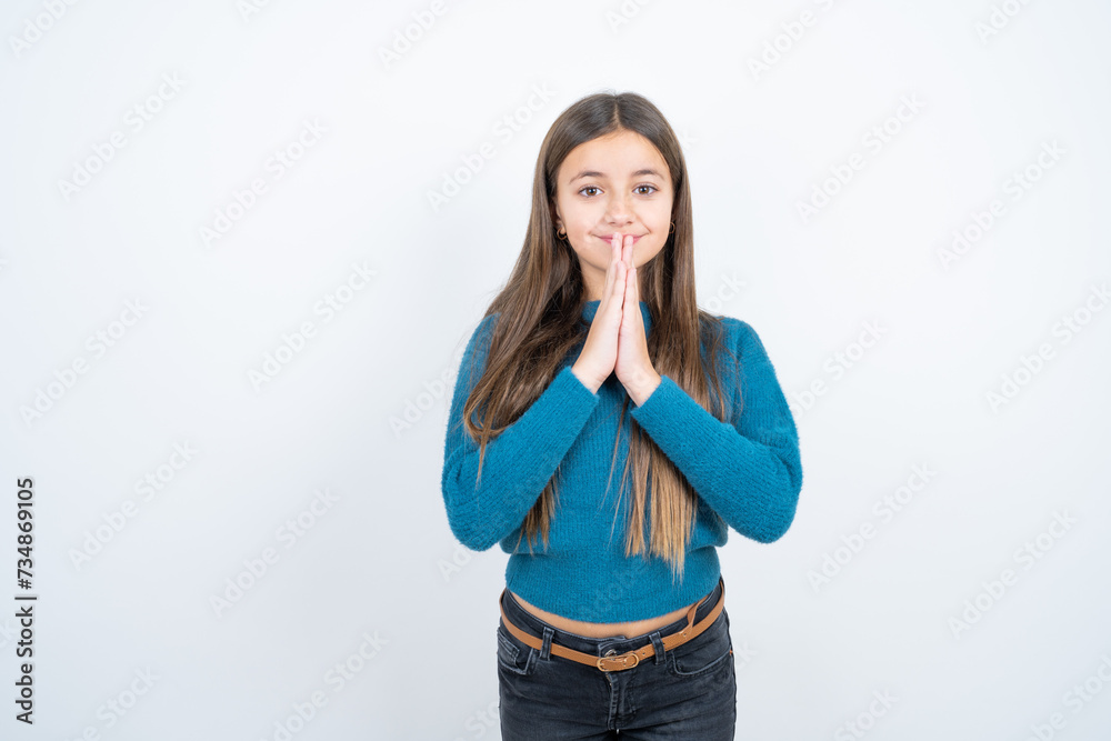 Young beautiful teen girl wearing blue T-shirt praying with hands together asking for forgiveness smiling confident. Young beautiful teen girl wearing blue T-shirt praying with hands together asking for forgiveness smiling confident.