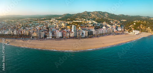 Panoramic aerial view of Lloret del Mar City. Mediterranean coastal town in Catalonia, Spain. One of the most popular Costa Brava beaches. Panoramic view of all region. Sunset warm colours.