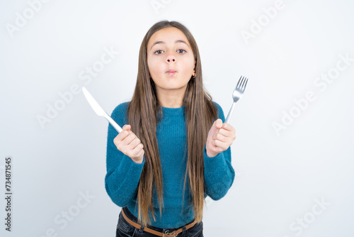 hungry Young beautiful teen girl wearing blue T-shirt holding in hand fork knife want tasty yummy pizza pie