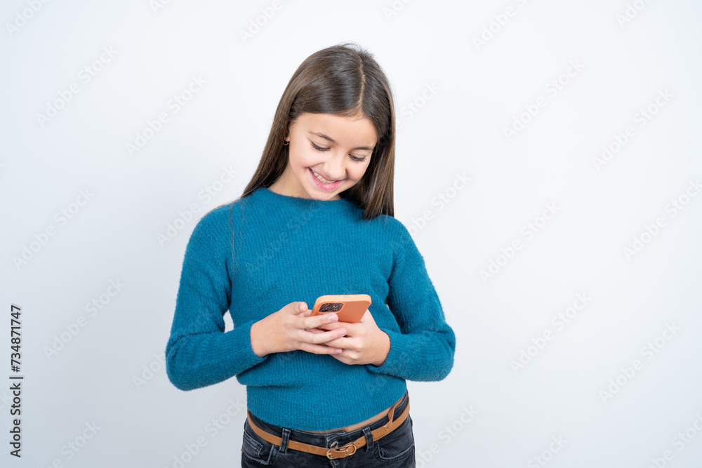 Excited Young beautiful teen girl wearing blue T-shirt winking and eye hold smart phone use read social network news Excited Young beautiful teen girl wearing blue T-shirt winking and eye hold smart phone use read social network news