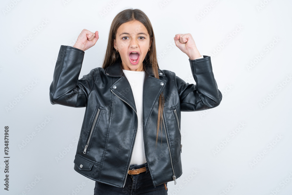 Shocked ecstatic Young beautiful teen girl wearing biker jacket win luck lottery raise hands up shout yea Shocked ecstatic Young beautiful teen girl wearing biker jacket win luck lottery raise hands up shout yea
