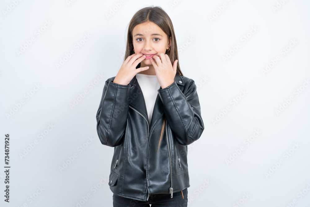 Speechless Young beautiful teen girl wearing biker jacket keeps hands near opened mouth reacts to shocking news stares wondered at camera Speechless Young beautiful teen girl wearing biker jacket keeps hands near opened mouth reacts to shocking news stares wondered at camera