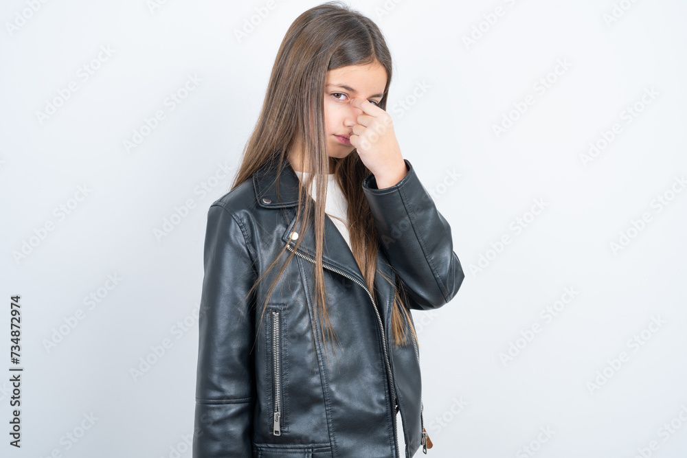 Sad Young beautiful teen girl wearing biker jacket suffering from headache holding hand on her face Sad Young beautiful teen girl wearing biker jacket suffering from headache holding hand on her face