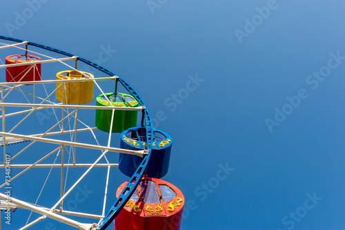 Carousel  Ferris Wheel  against a blue clear sky. Place for inscription.