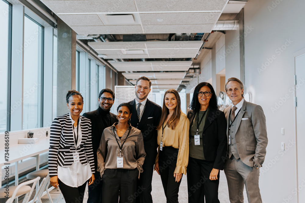 Portrait of smiling multiracial colleagues standing in corridor Portrait of smiling multiracial colleagues standing in corridor