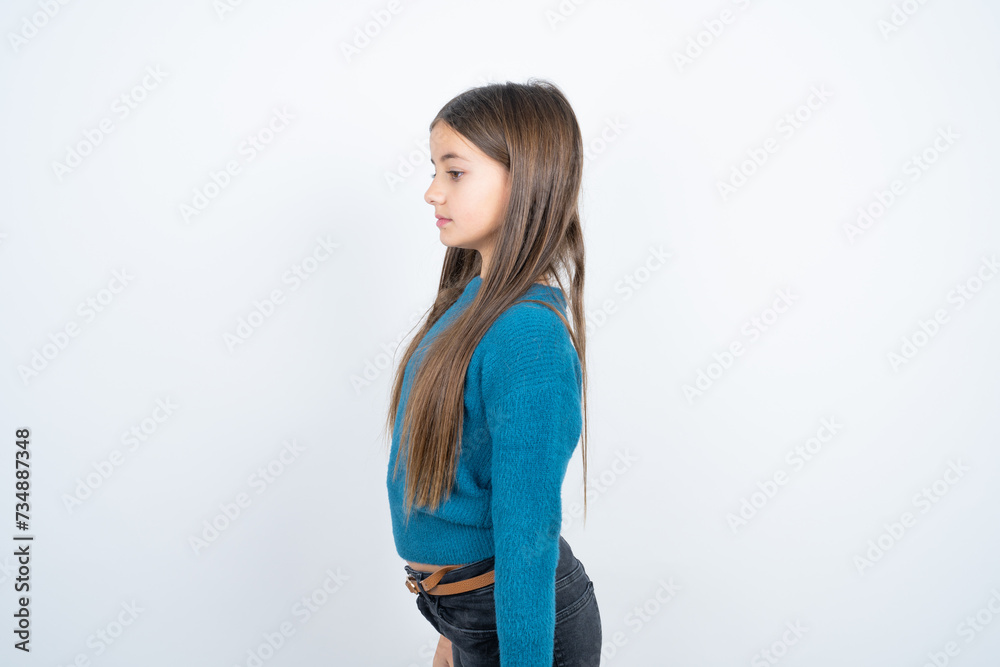 beautiful kid girl wearing blue sweater looking to side, relax profile pose with natural face with confident smile. beautiful kid girl wearing blue sweater looking to side, relax profile pose with natural face with confident smile.