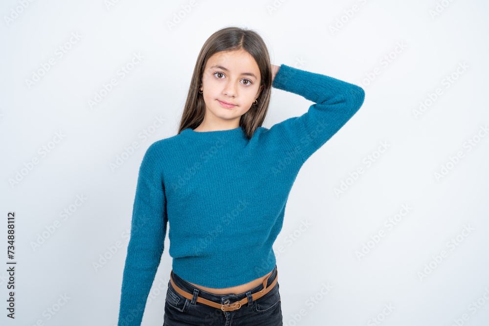 beautiful kid girl wearing blue sweater being confused and wonders about something. Holding hand on head, uncertain with doubt. Pensive concept. beautiful kid girl wearing blue sweater being confused and wonders about something. Holding hand on head, uncertain with doubt. Pensive concept.