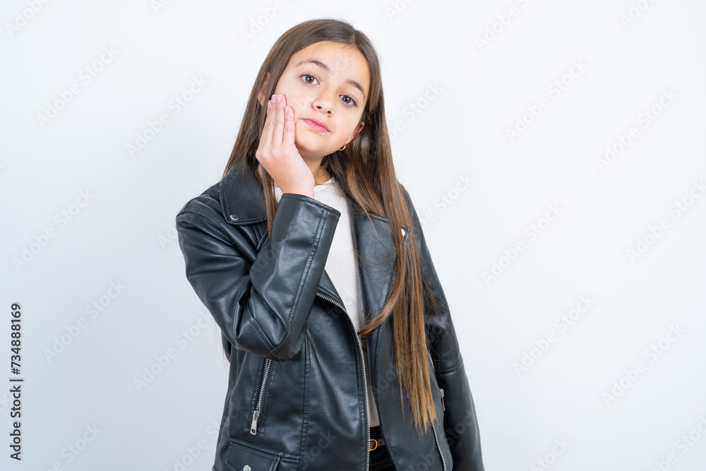 Photo of beautiful kid girl wearing biker jacket enjoy fresh perfect smooth skin touch face Photo of beautiful kid girl wearing biker jacket enjoy fresh perfect smooth skin touch face