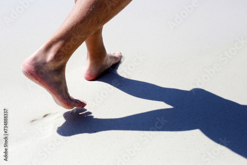 Men walking on sand beach