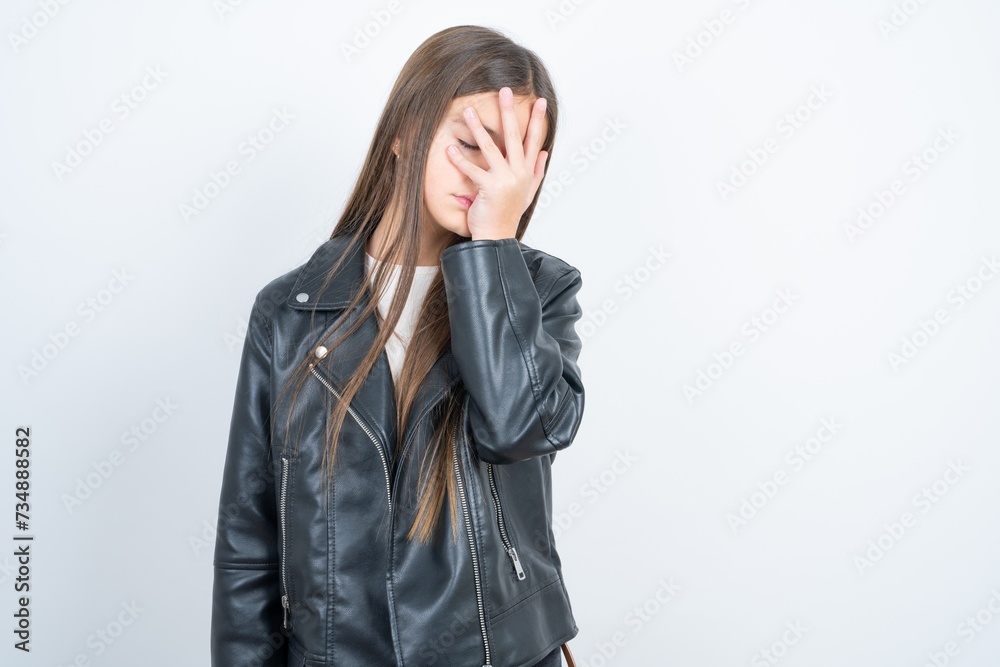 beautiful kid girl wearing biker jacket over white background with sad expression covering face with hands while crying. Depression concept. beautiful kid girl wearing biker jacket over white background with sad expression covering face with hands while crying. Depression concept.