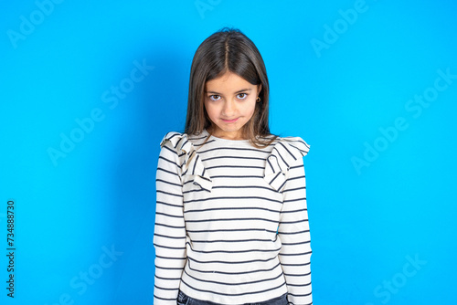 Displeased upset beautiful kid girl wearing striped T -shirt frowns face as going to cry, being discontent and unhappy as can't achieve goals, Disappointed model has troubles